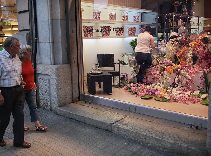Girona: Especial Temps de Flors .Aparador de Suministres Girona a la Gran Via, molt colorista i amb flors diverses en una de les vitrines. I rotonda del Trueta, amb ocells recreats amb materials.