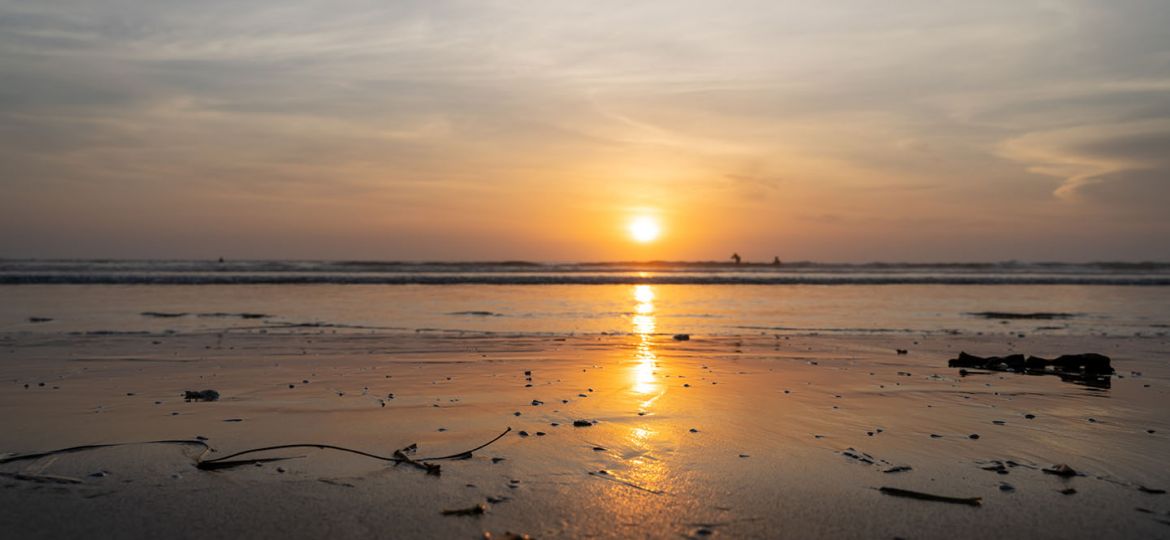 Sunset over an sea with waves breaking on the beach